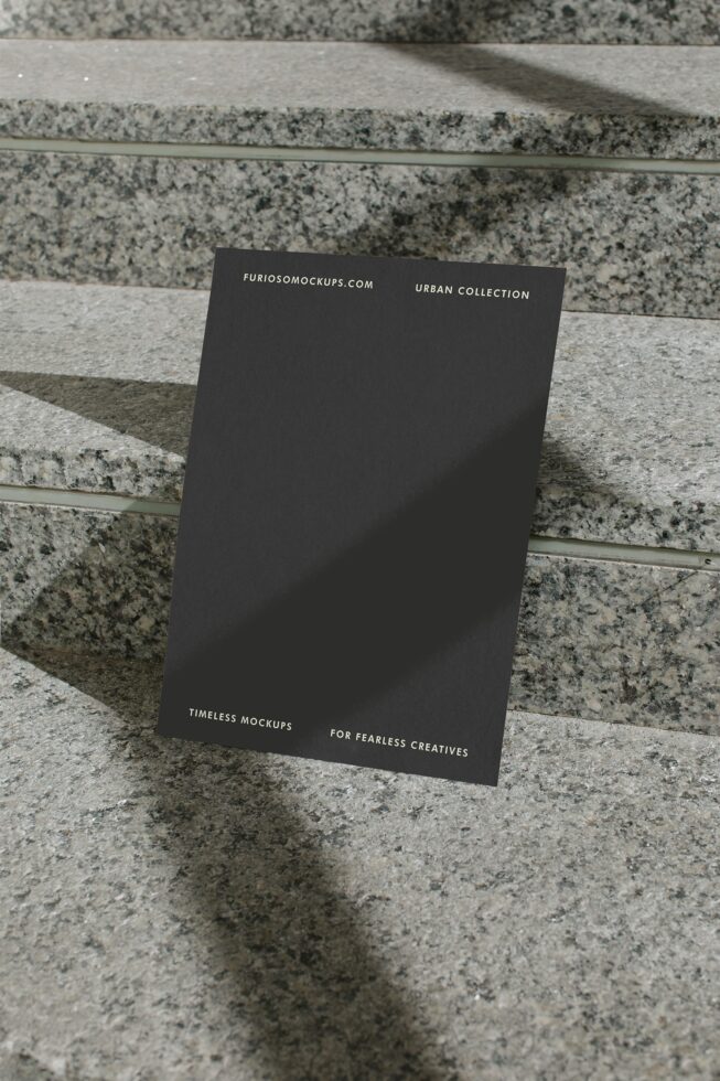 Charcoal folded card standing on granite surface with minimal typography visible