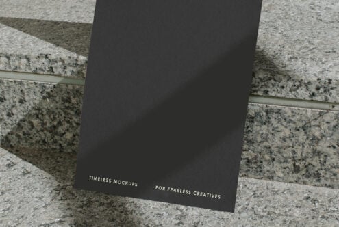 Dark card stood upright on layered stone showing lower portion with small text