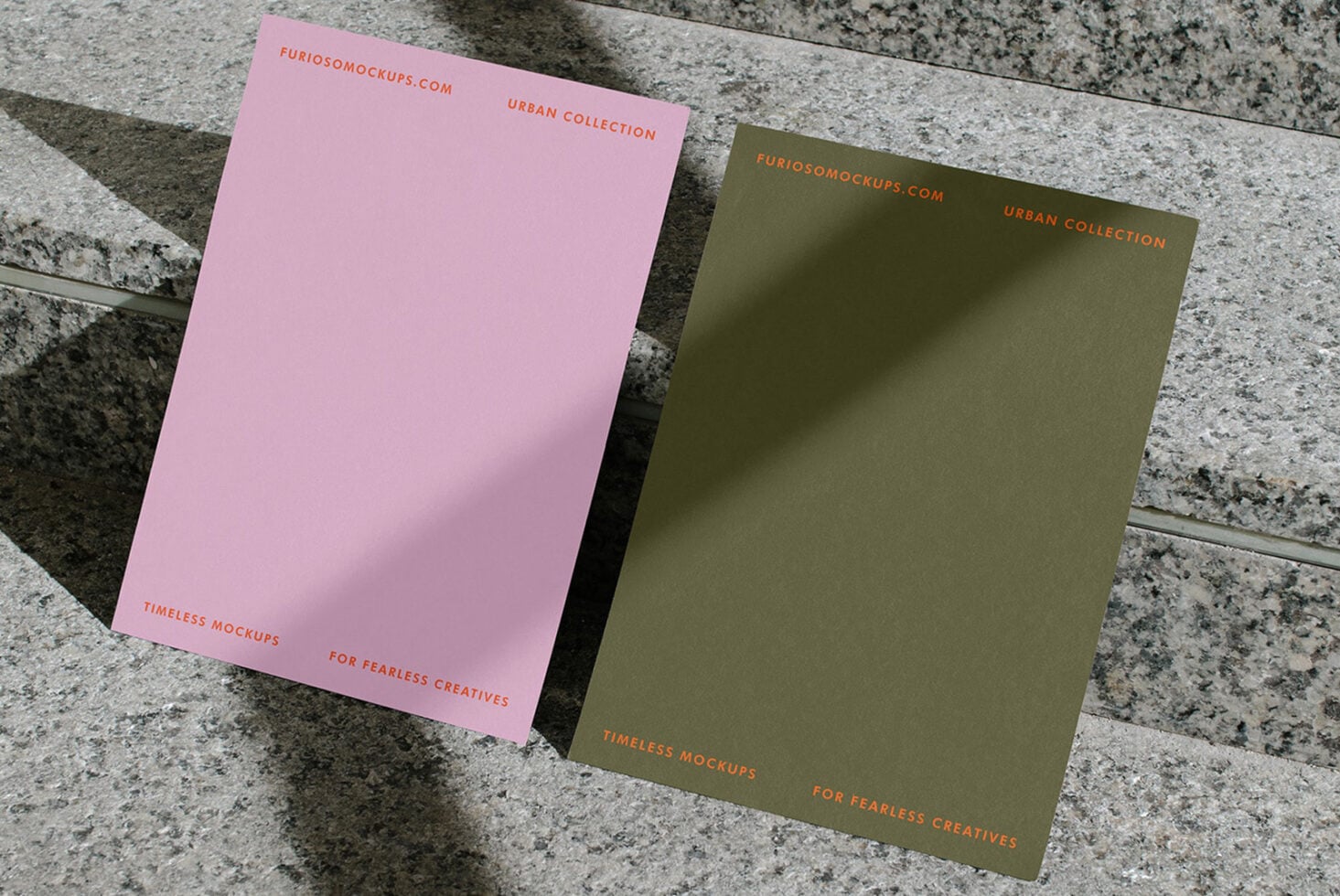Pink, olive, plus cream colored cards fanned out on textured concrete surface