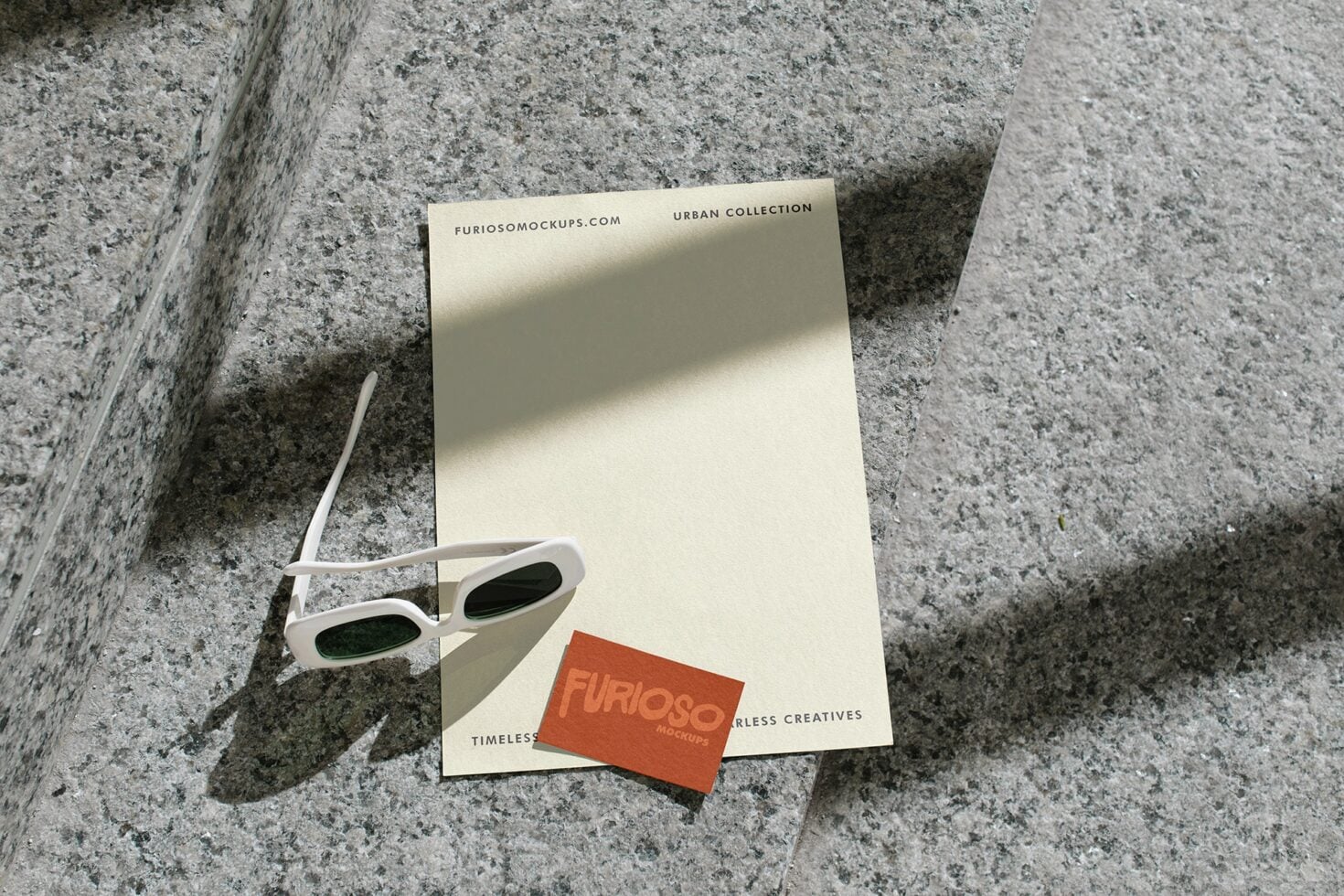 Cream letterhead with white sunglasses plus orange card on textured ground