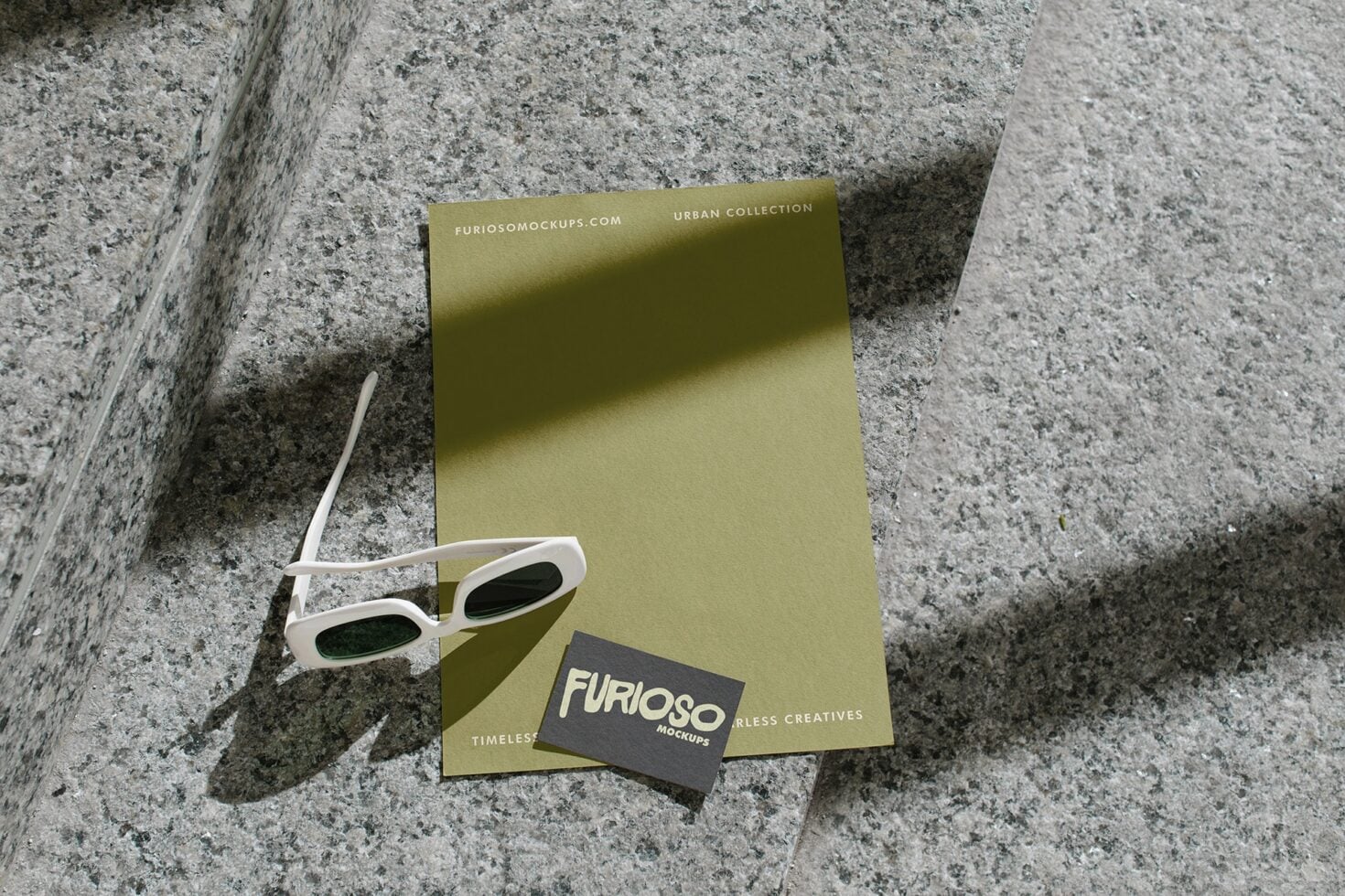 Olive stationery set with white frames casting shadows on concrete steps