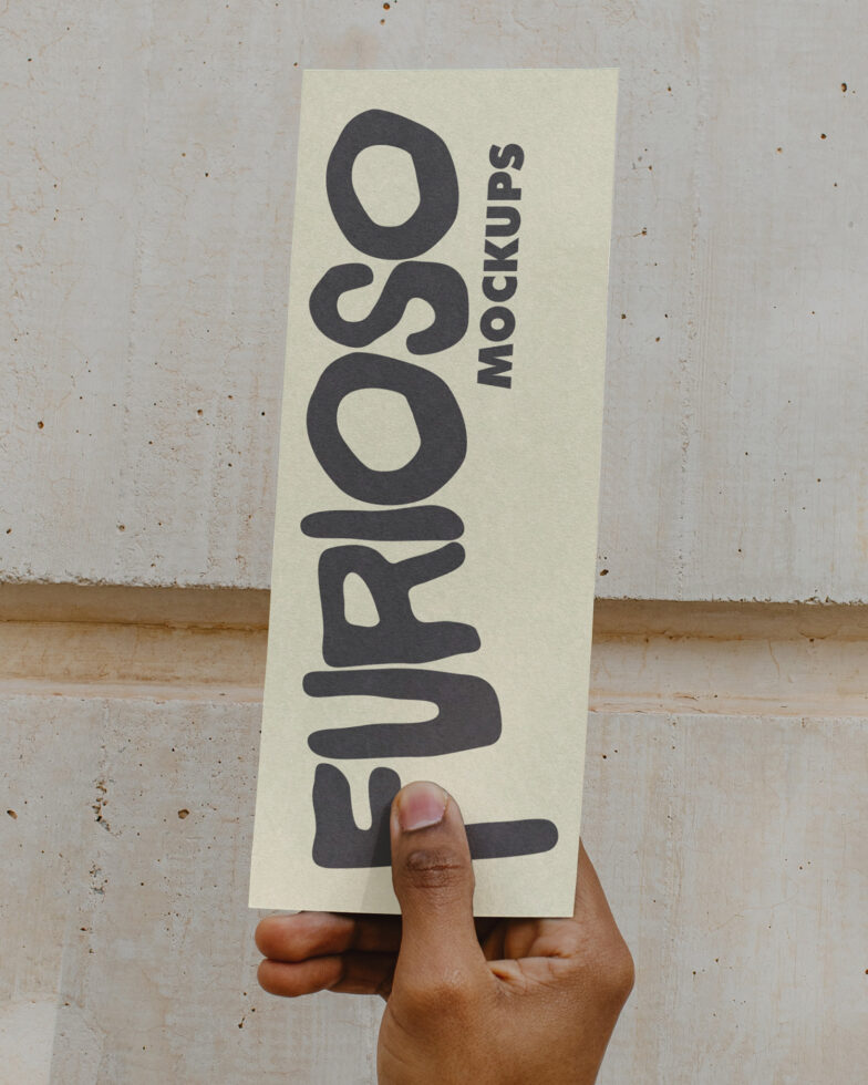 Cream vertical card mockup with dark text held in front of textured wall
