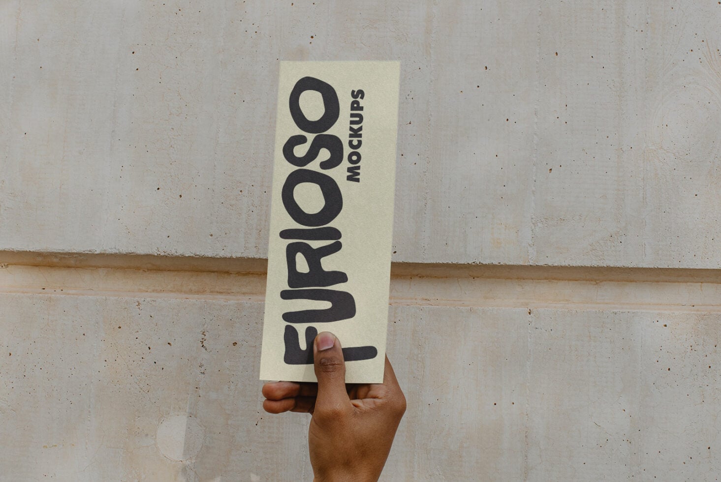 Cream business card held vertically with black sans-serif text reading Furioso Mockups