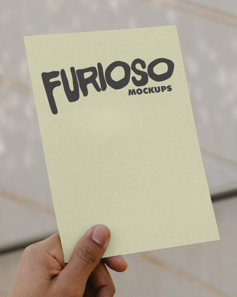 Pale yellow card held in hand with black Furioso Mockups text in casual handwritten style