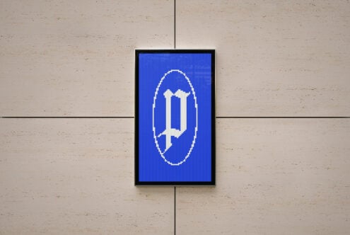 Framed display with pixelated cross symbol in white on deep blue