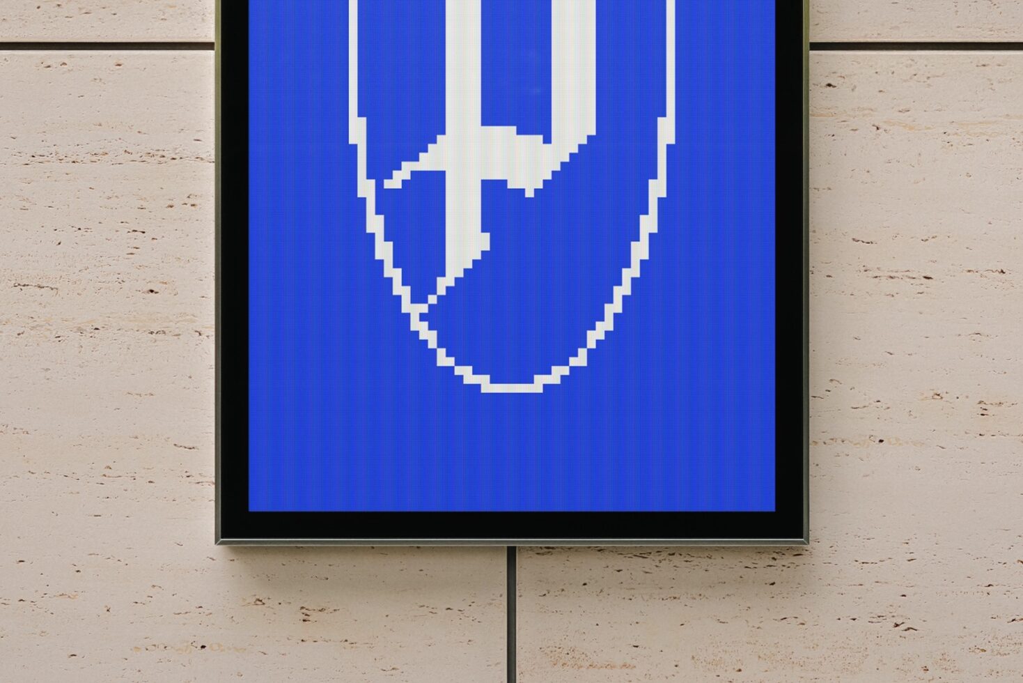 Framed screen showing pixelated smiley face on bright blue background