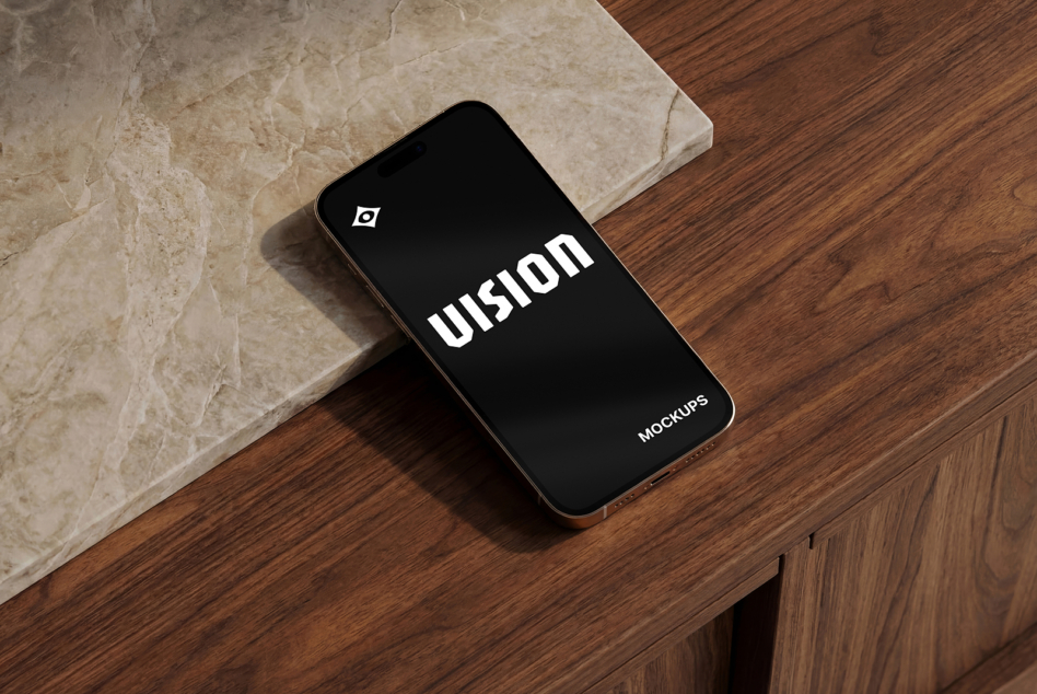 Smartphone lying flat on marble tile with black screen showing VISION text mockup