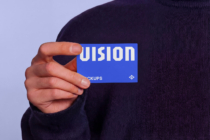 Hand holding blue business card with white UISION text against lavender background