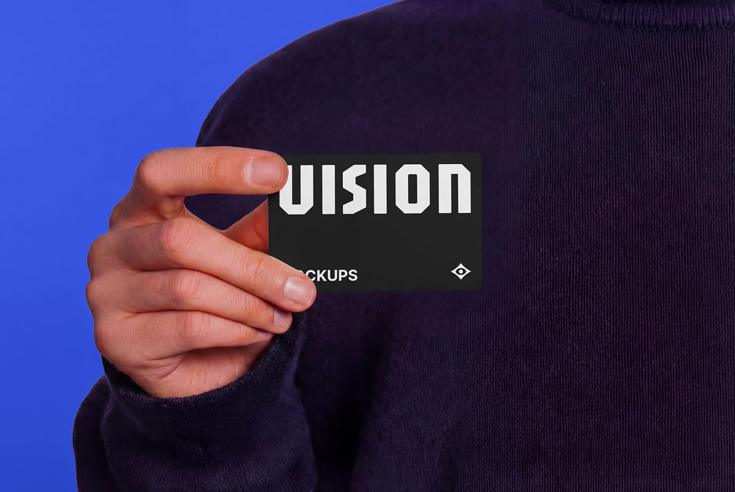 Hand holding black business card with white UISION text against blue background