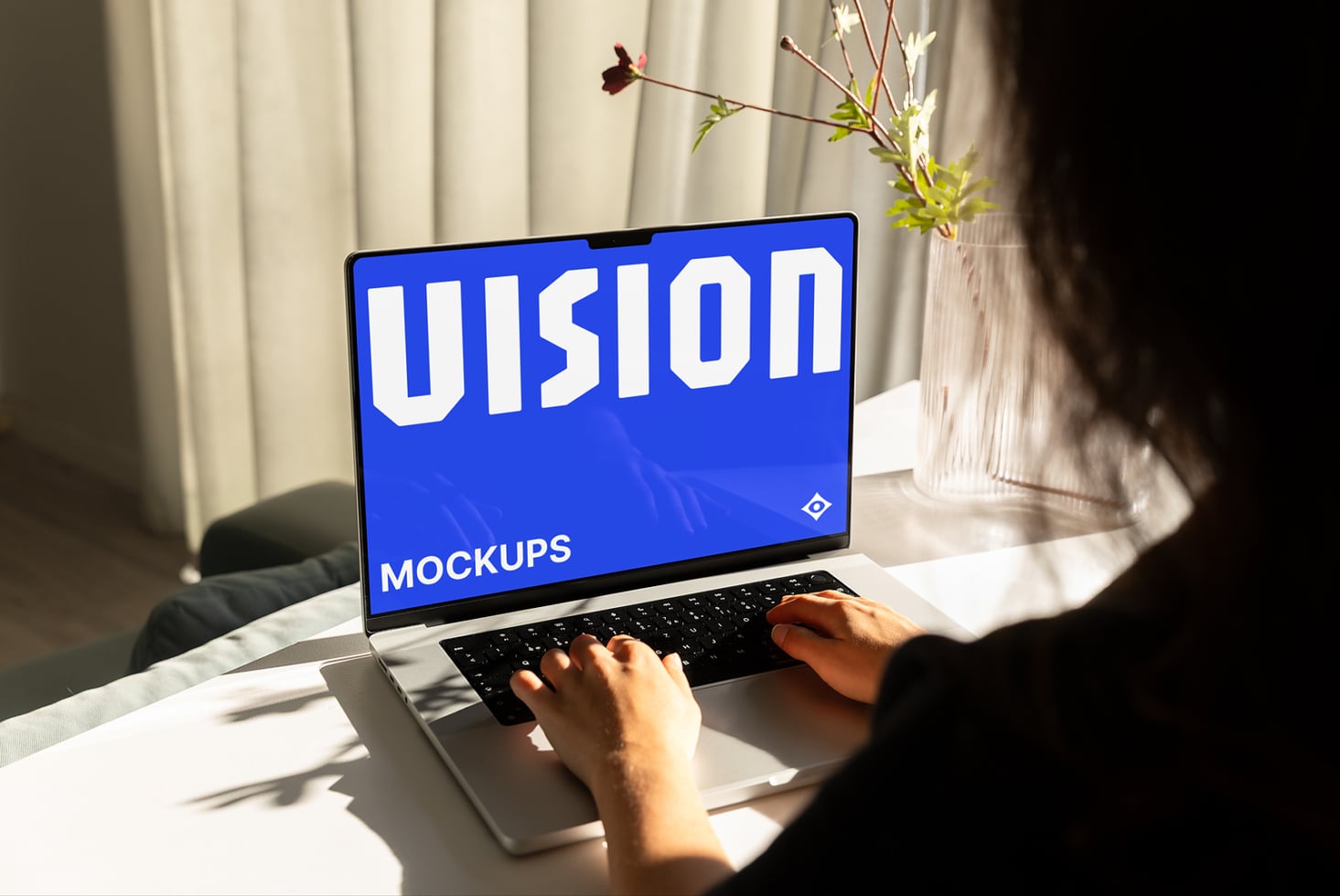 Person typing on laptop with black screen display in bright daylit workspace