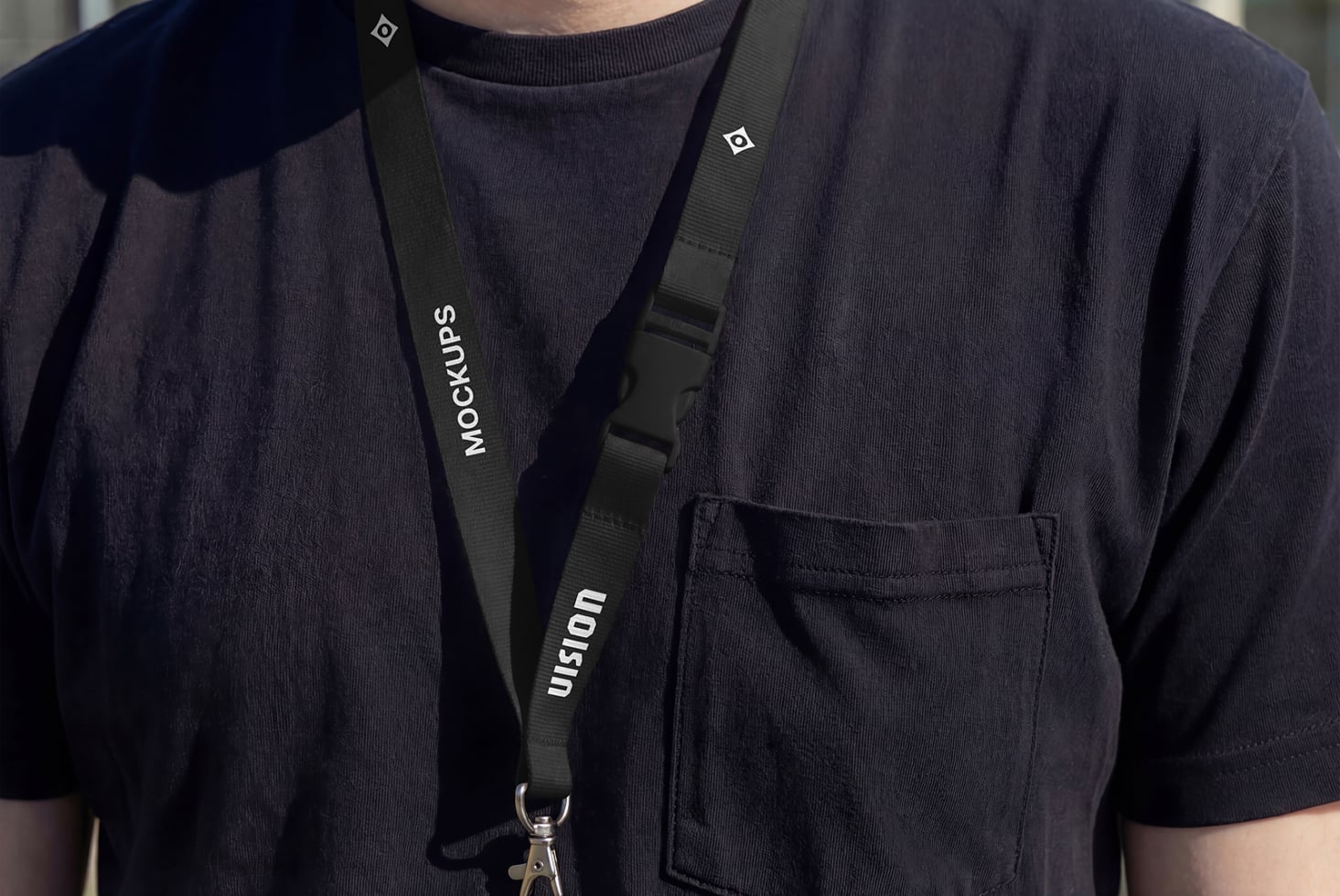 Black lanyard worn over dark t-shirt with metal clip