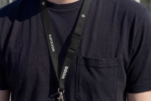 Black lanyard worn over dark t-shirt with metal clip