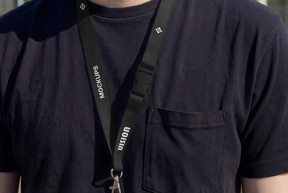 Black lanyard worn over dark t-shirt with metal clip