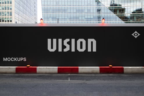 Black hoarding with VISION in gray letters, red warning barriers, urban skyline