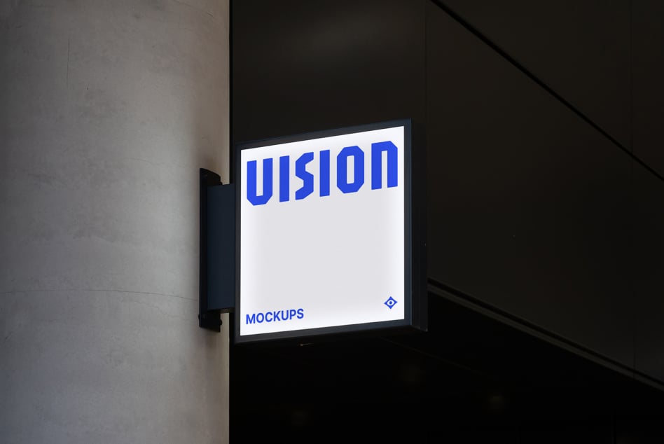 Illuminated storefront sign mounted on dark wall showing white VISION text on light background