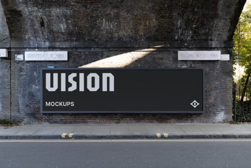 Large black billboard with VISION text on weathered brick wall