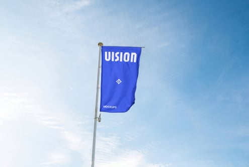 Bright blue flag banner on white pole waving against cloudy blue sky