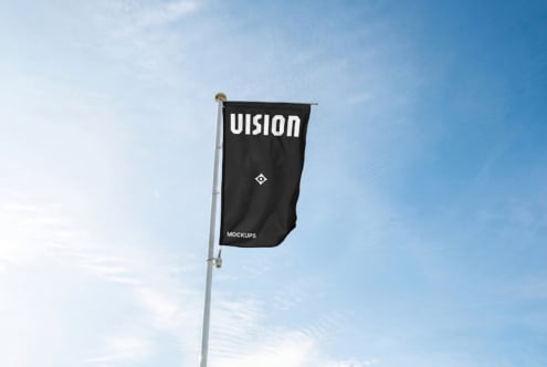 Black flag banner mounted on white pole against clear blue sky