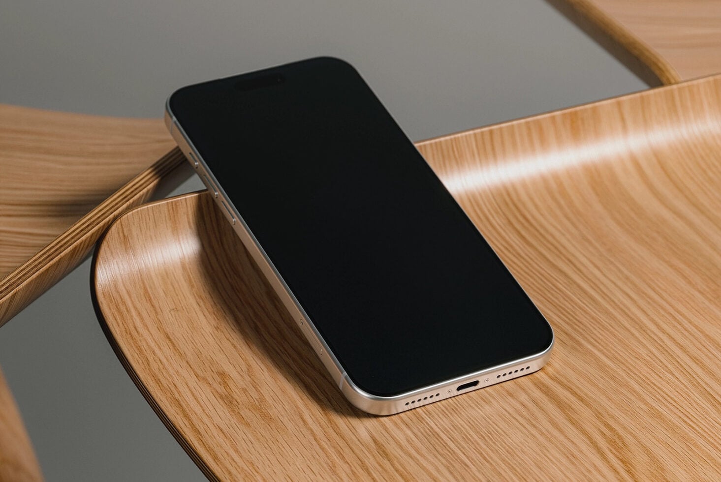 Gold iPhone on wooden chair with red text overlay mockup