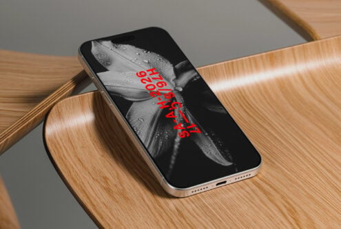 iPhone on wooden table showing wet flower with red text overlay