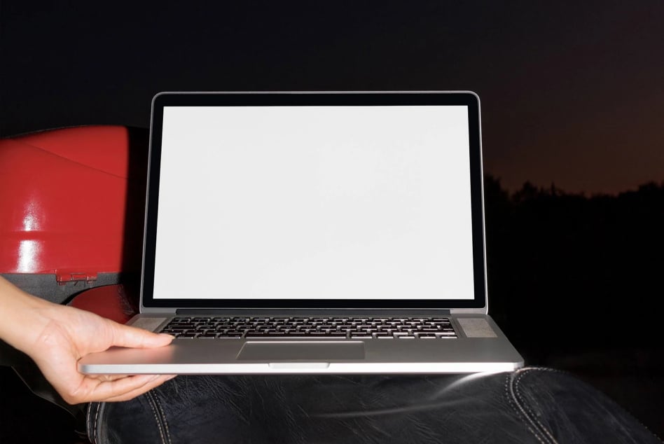 Laptop mockup with blank screen held in hands wearing red jacket against dark background