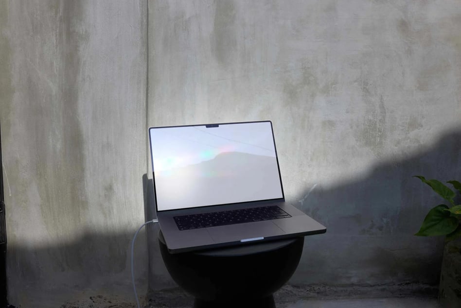 Laptop mockup on concrete pedestal with textured wall background, natural light