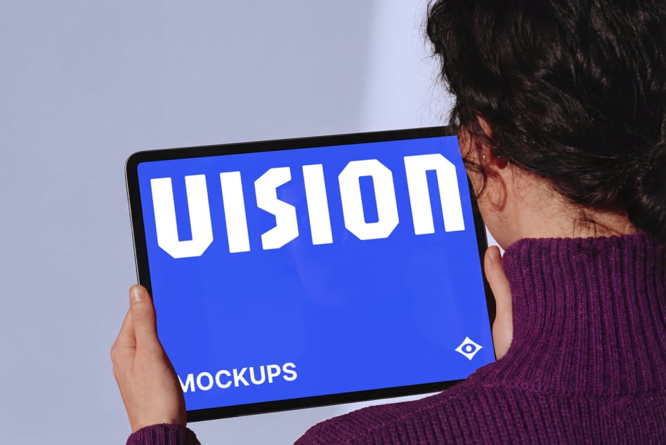 Person holding tablet with blue screen displaying VISION text