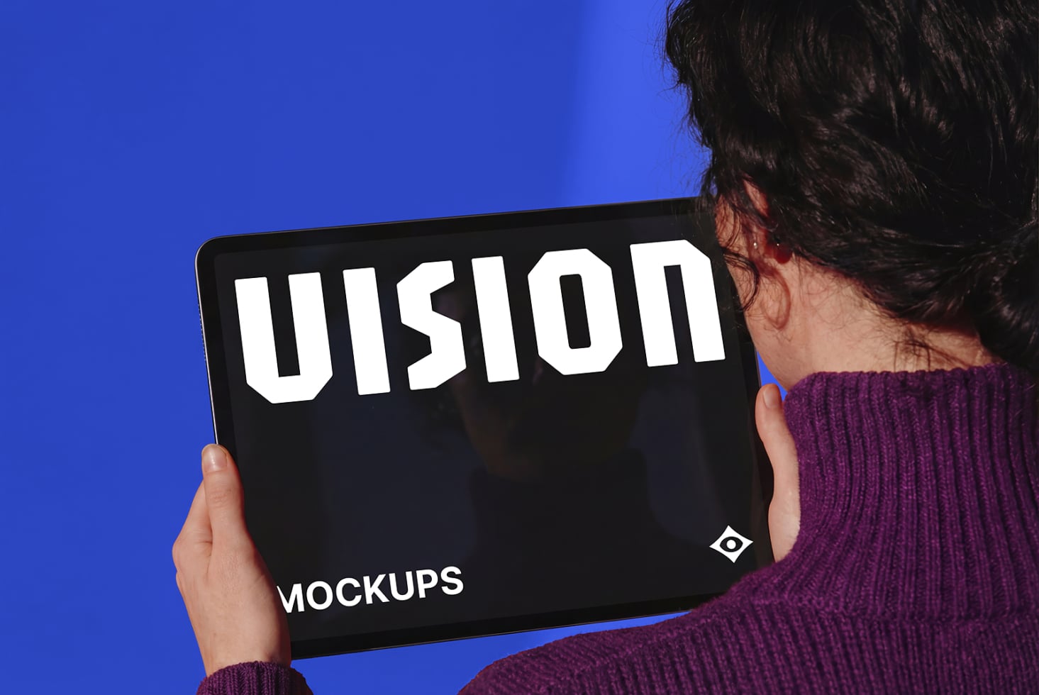 Person holding tablet with black screen displaying VISION text