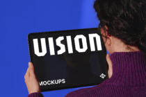 Person holding tablet with black screen displaying VISION text