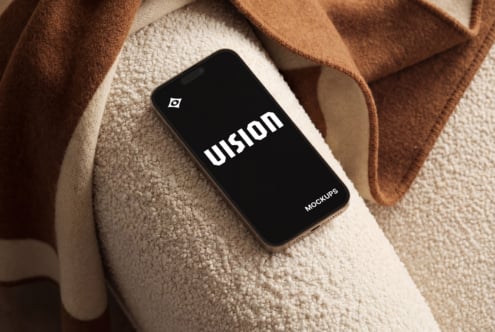 Phone mockup with black screen on cream texture with brown fabrics
