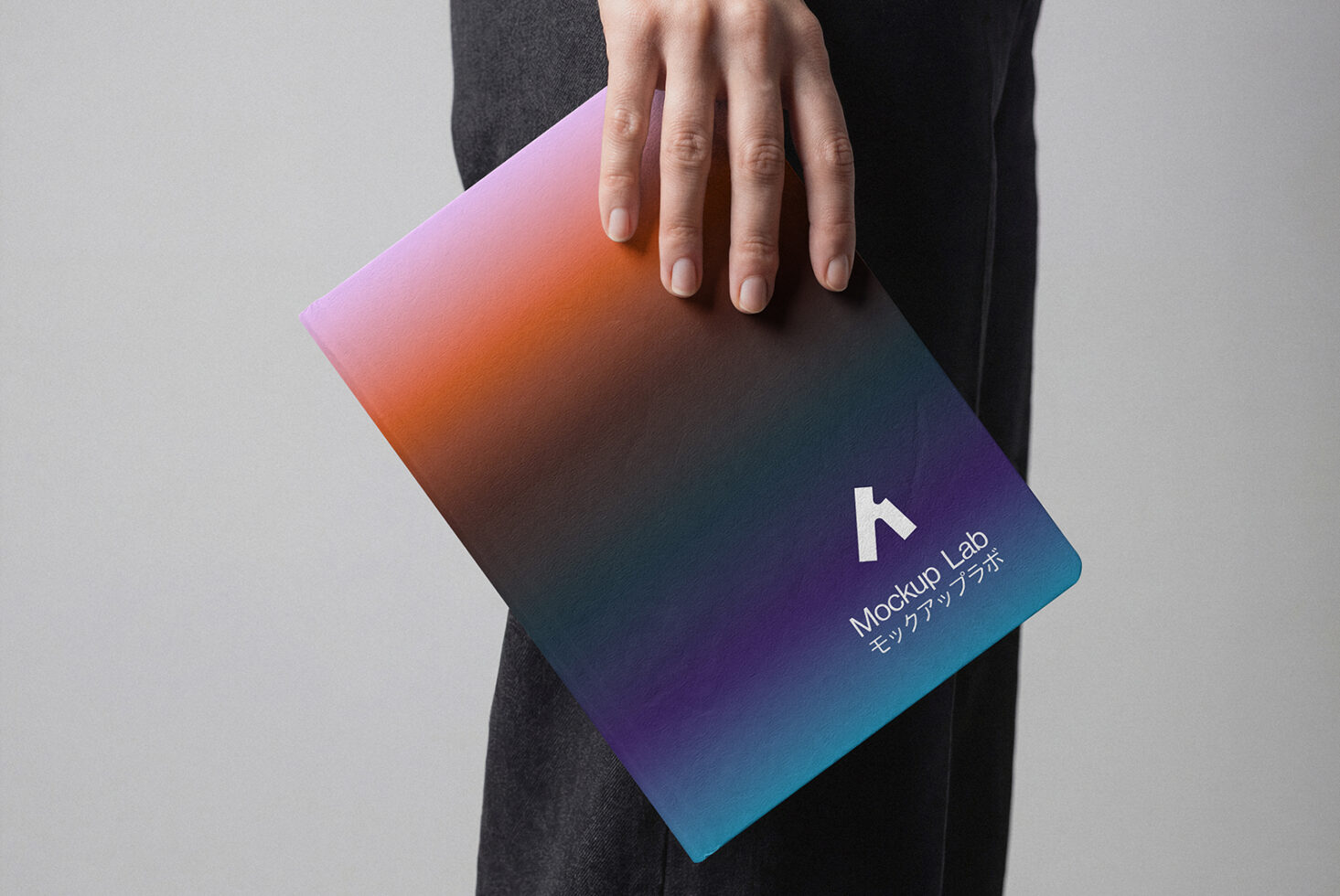 Hand gripping curved notebook showing vibrant gradient colors