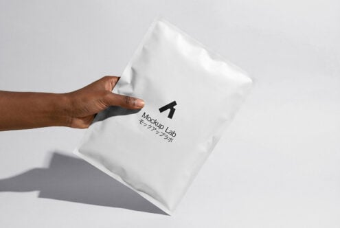 Hand holding white puffy envelope mockup with logo stamp