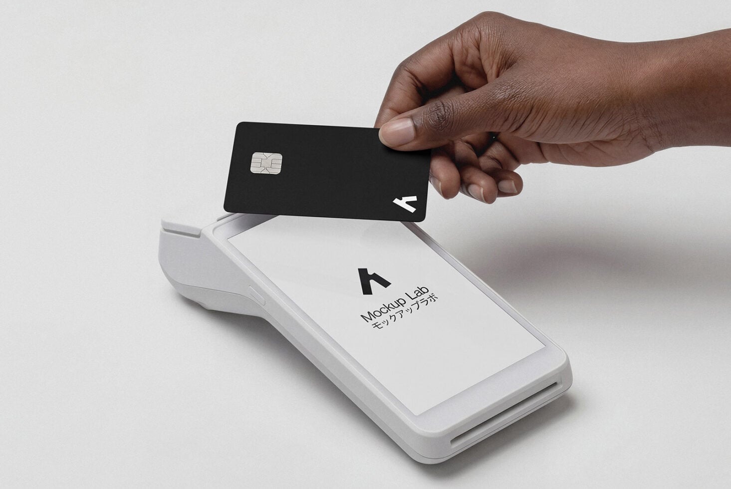 Hand swiping black credit card through white payment terminal reader device