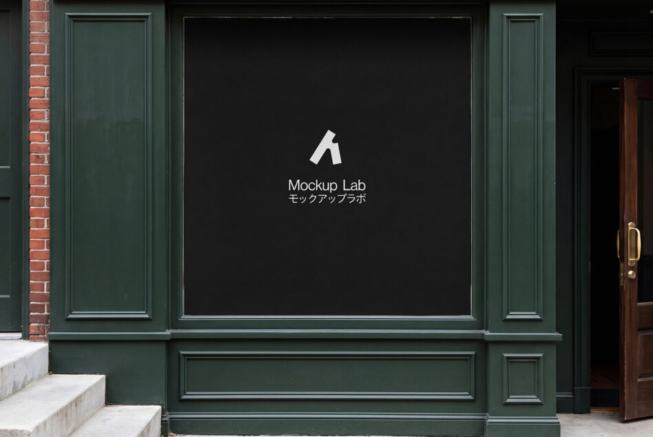 Large storefront window in green frame showing dark display with logo centered