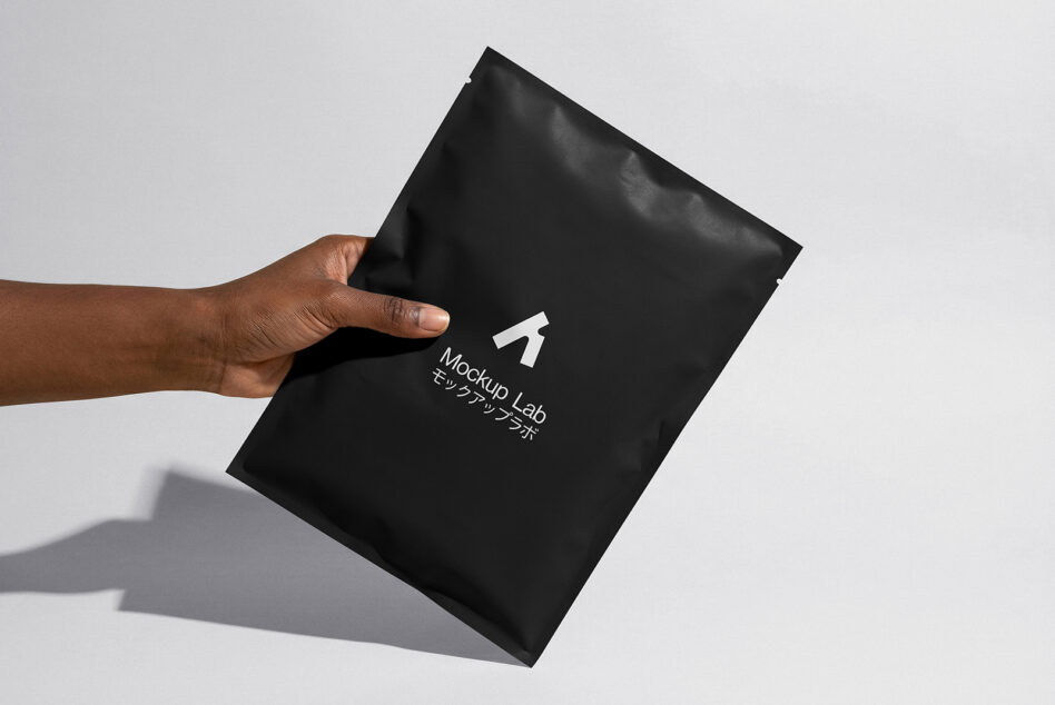 Hand tilting black envelope mockup showing creased texture