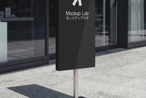 Tall black vertical sign displaying white branding on street