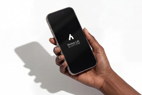 Hand holding phone with black screen showing white Mockup Lab logo icon