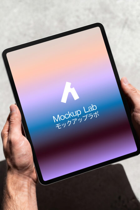 iPad with gradient peach to blue display held in hands showing Mockup Lab
