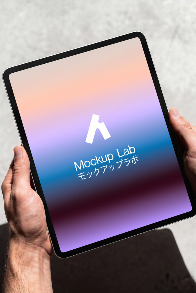 iPad with gradient peach to blue display held in hands showing Mockup Lab