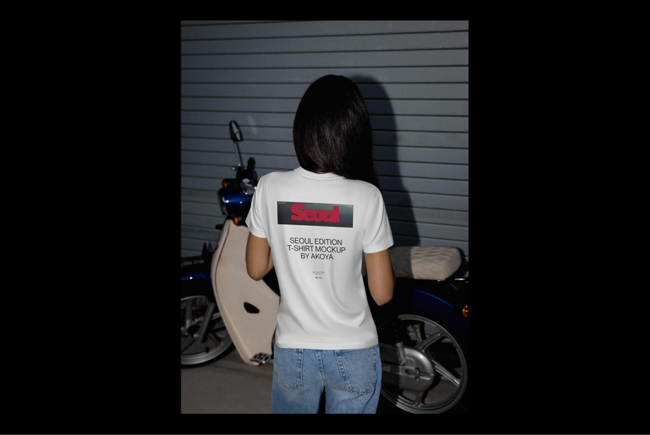 Designer showcases a Seoul Edition T-shirt mockup on a woman standing by a scooter. Ideal for apparel mockups, fashion design, digital assets.