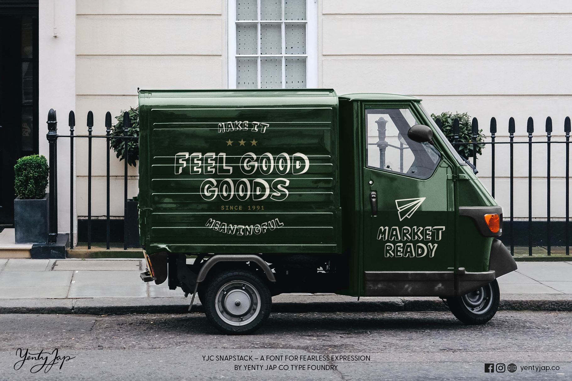 Green delivery truck with feel good goods lettering parked in front of white building