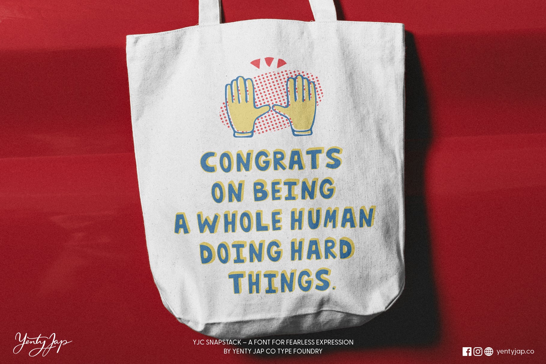 White tote bag with high five hands graphic, congratulations text on red background