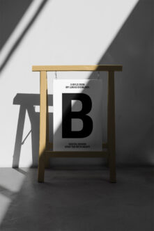 Wooden hanging sign frame with white card showing large black B letter