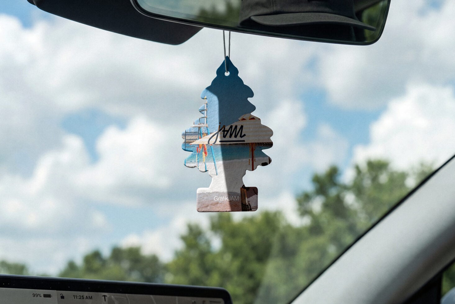 Tree-shaped car air freshener hanging from rearview mirror with photo collage design