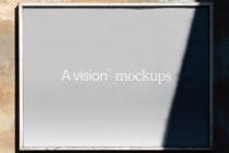 Weathered white frame mounted on textured wall displaying A vision mockups text
