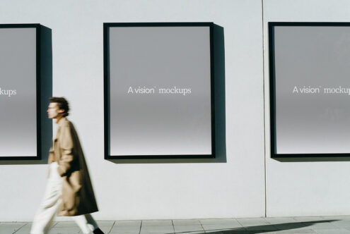 Woman walking past gallery wall with three framed displays featuring gray gradient backgrounds