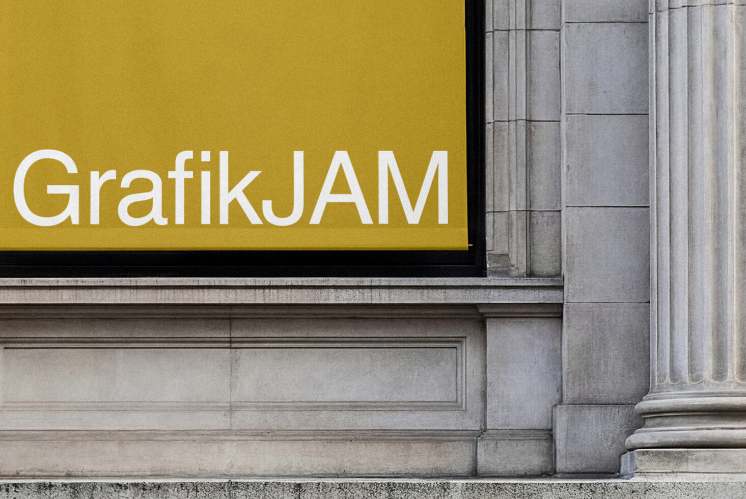 Gold banner storefront sign with GrafikJAM text on building