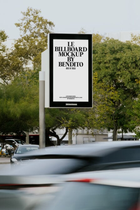 Outdoor billboard display with white panel, leafy trees blurred in background