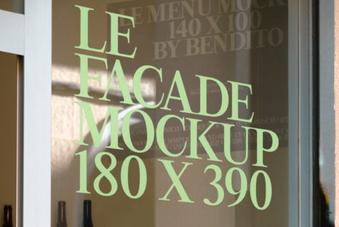 Shop window mockup with green sans serif text displayed on glass panel in daylight