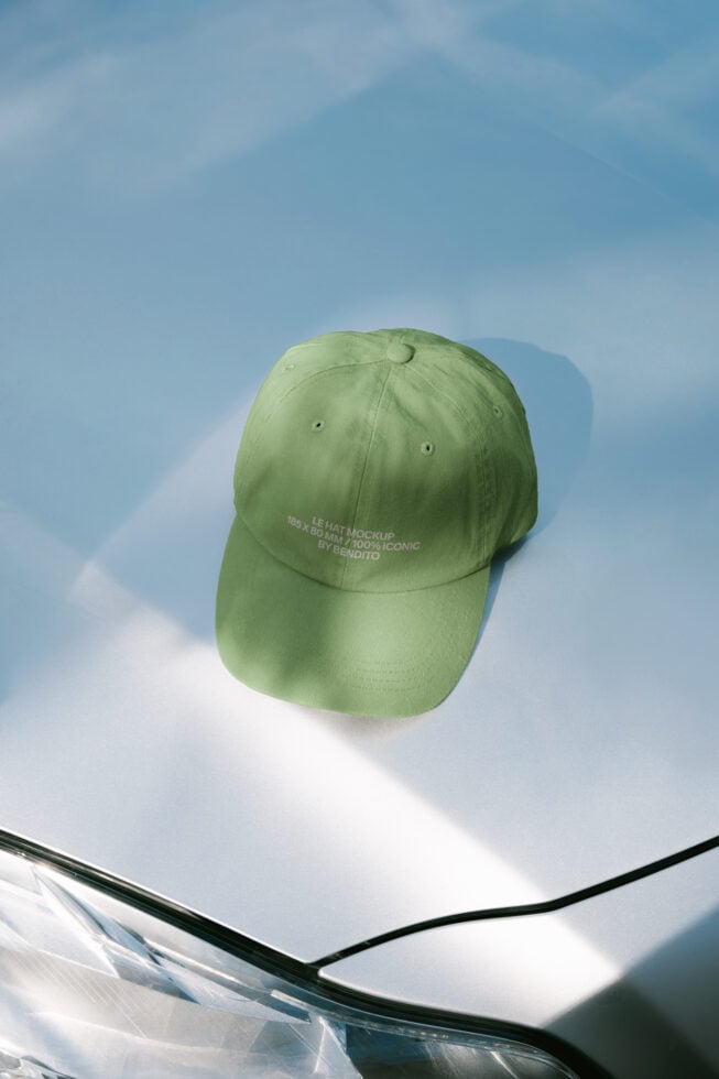 Lime green baseball cap on white surface with blue sky backdrop